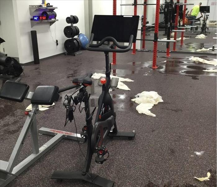Gym with workout equipment and standing water on the floor