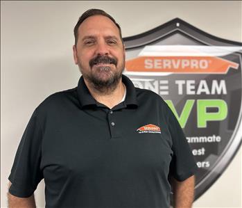 Project Manager Standing in front of Servpro Fleet