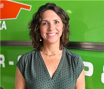 Female Employee Smiling in front of white wall